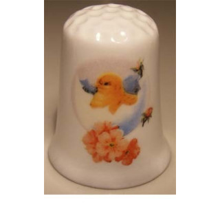 Kuiken uit ei op een porselein vingerhoedje