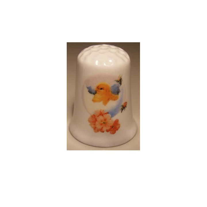 Kuiken uit ei op een porselein vingerhoedje