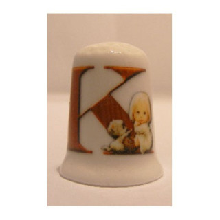 Letter K met meisje op een porselein vingerhoedje