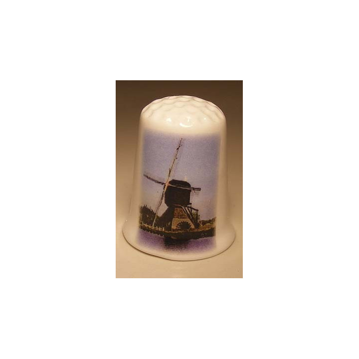 Molen langs het water op een porselein vingerhoedje Molen langs het water op een porselein vingerhoedje