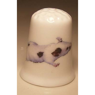 Muis met vlekken op een porselein vingerhoedje