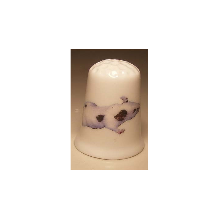 Muis met vlekken op een porselein vingerhoedje