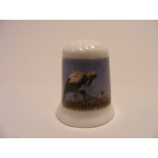 Ooievaar met jong op een nest op een porselein vingerhoedje