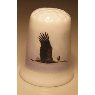 Ooievaar vliegend op een porselein vingerhoedje