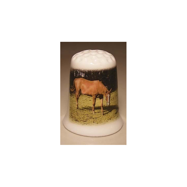 Paard op het gras op een porselein vingerhoedje