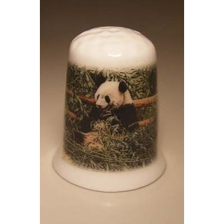 Panda zit tegen een hek op een porselein vingerhoedje