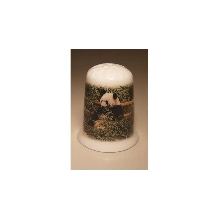 Panda zit tegen een hek op een porselein vingerhoedje