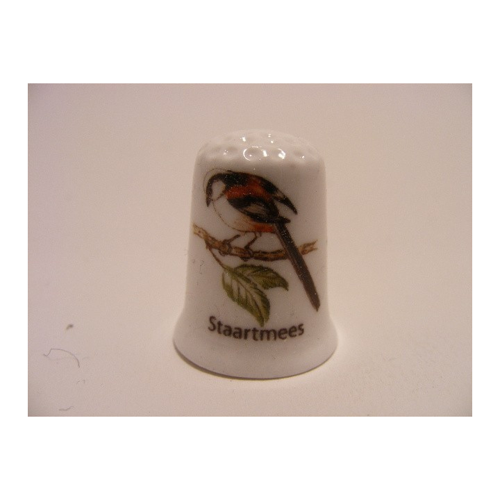 Staartmees zangvogel Aegithalos caudatus op een porselein vingerhoedje