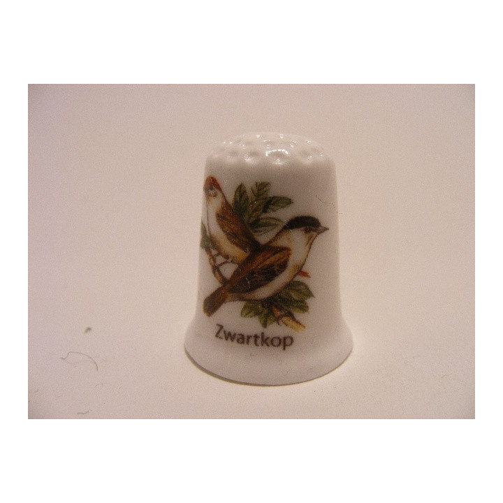 Swartkop zangvogel Sylvia atricapilla op een porselein vingerhoedje