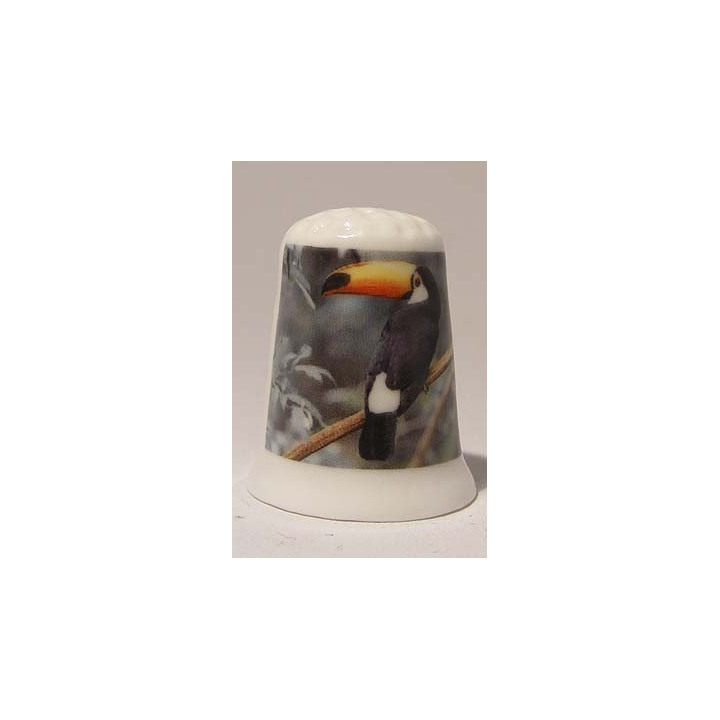 Toekan op tak op een porselein vingerhoedje