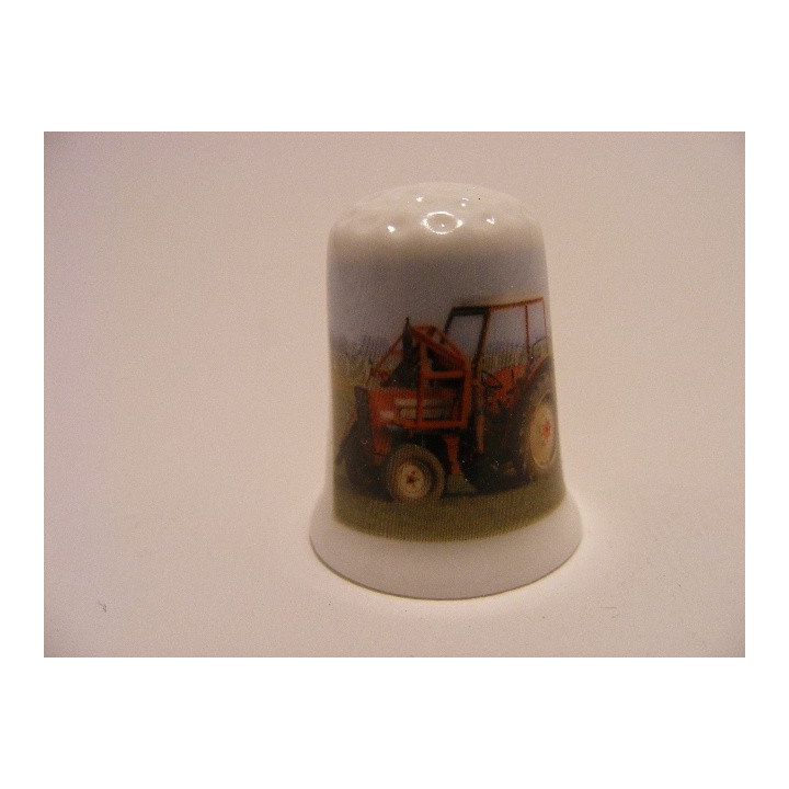 Tractor rood op een porselein vingerhoedje