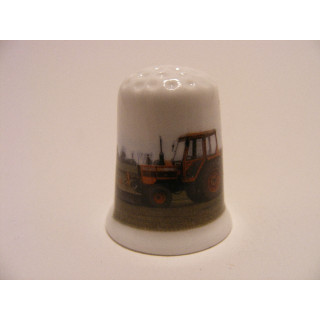 Tractor rood op een porselein vingerhoedje