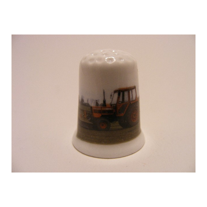 Tractor rood op een porselein vingerhoedje