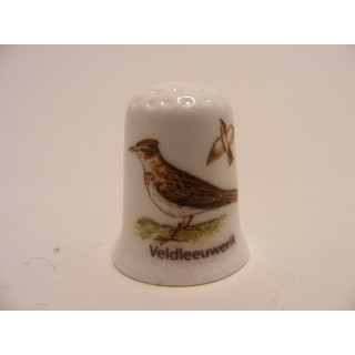 Veldleeuwerik zangvogel Alauda arvensis op een porselein vingerhoedje Veldleeuwerik zangvogel Alauda arvensis op een porselein vingerhoedje