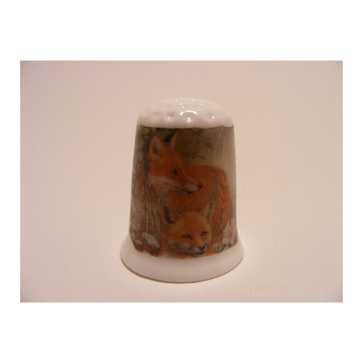 Vos met jong liggend op een porselein vingerhoedje