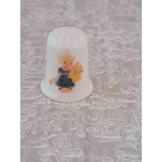 Hollands bloemenmeisje op een porseleinen vingerhoed Hollands bloemenmeisje op een porseleinen vingerhoed