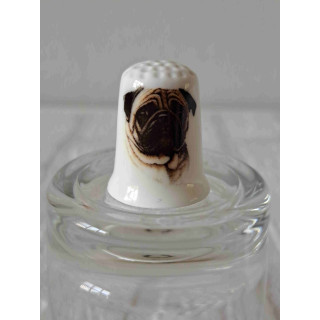 Mopshond hond op een porselein vingerhoedje