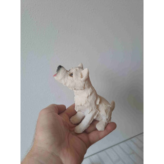 West highland terrier hond rechtop zittend en kijkend omhoog