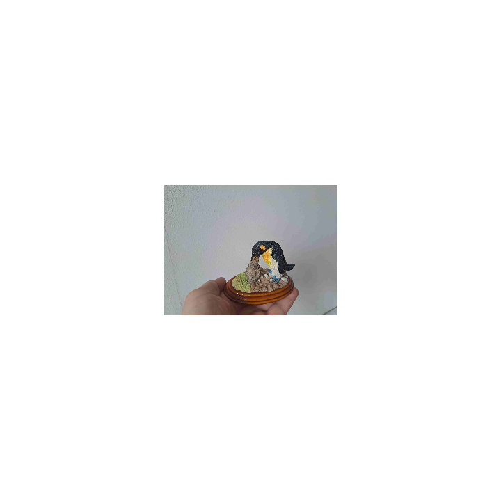Koningspinguin geeft zijn jong eten op een houten plateau
