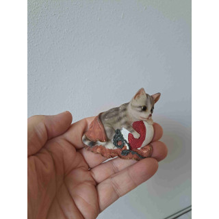 Keukenmagneet poes speelt met strandbal en handdoek
