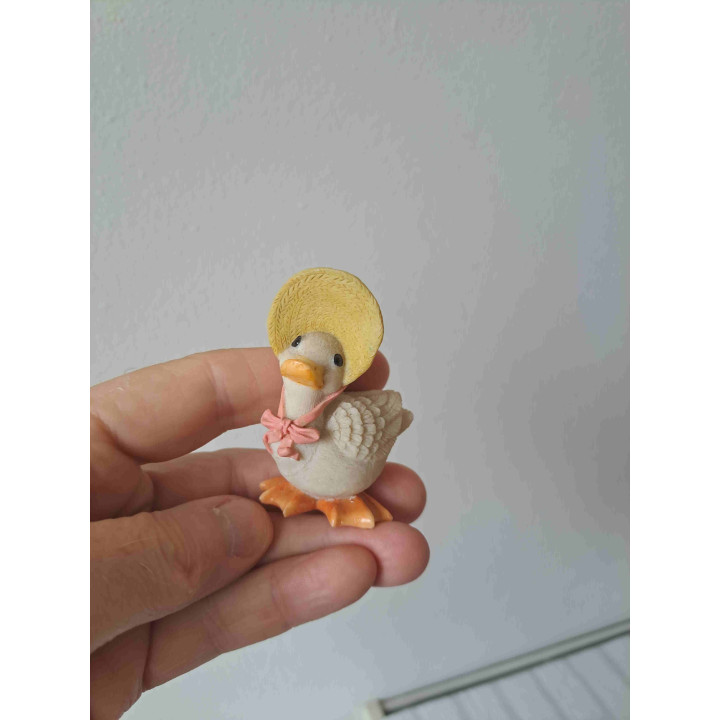 Gans van kunsthars met hoed en lichtroze strik 5x3.5x8cm