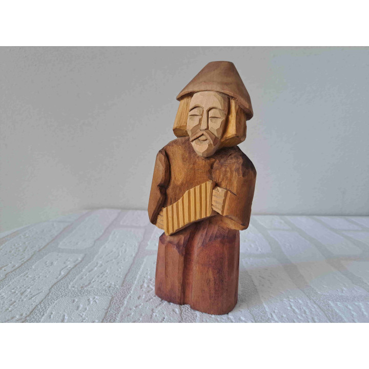 Muzikant met panfluit uit hout gesneden