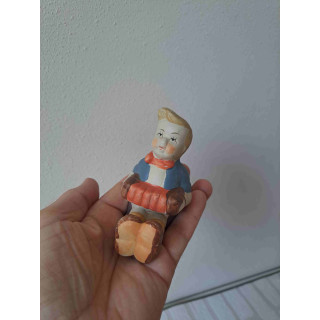 Jongen zittend op de grond speelt op een accordeon