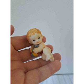 Kind van kunsthars met een strandbal 7x3.5x4.5cm