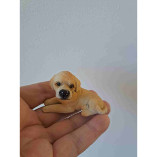 Labrador blond puppy hond van kunsthars liggend op de grond