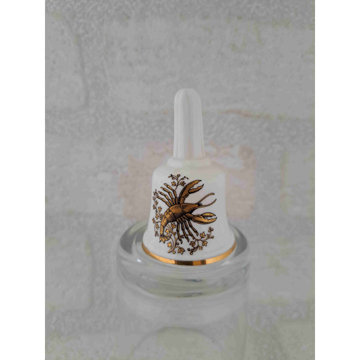 Porselein tafelbelletje met een goudkleurig kreeft sterrenbeeld opdruk