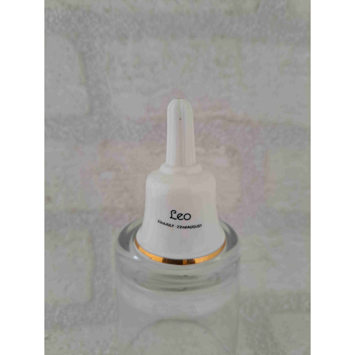 Porselein tafelbelletje met een goudkleurig leeuw sterrenbeeld opdruk