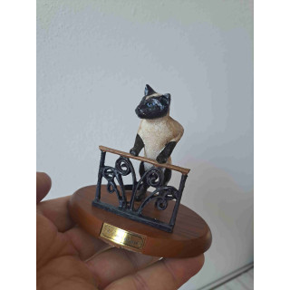 Een Siamees poes van kunsthars op een plateau met hek