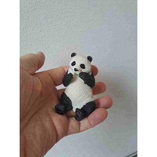 Panda van kunsthars eet een bamboe takje