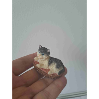 Poes van kunsthars ligt lekker in zijn mandje