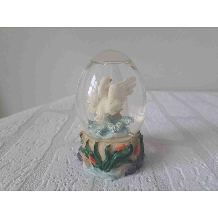 Sneeuwbol van glas met zwaan met vleugels wijd erin