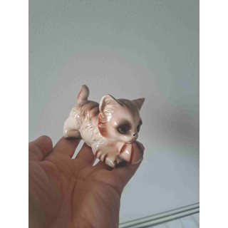 Poes van porselein speelt met strandbal