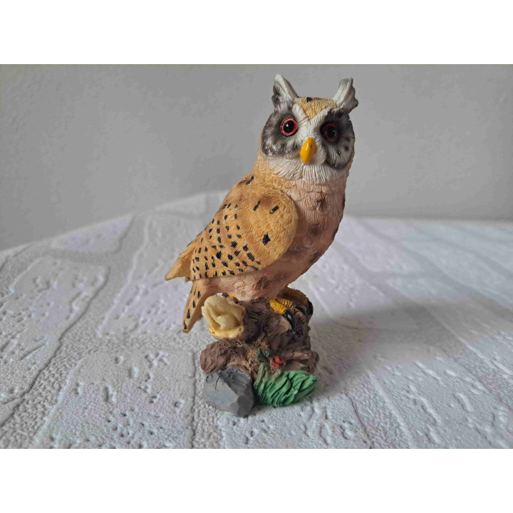 Uil met grote ogen staand op een boomstronk Uil met grote ogen staand op een boomstronk