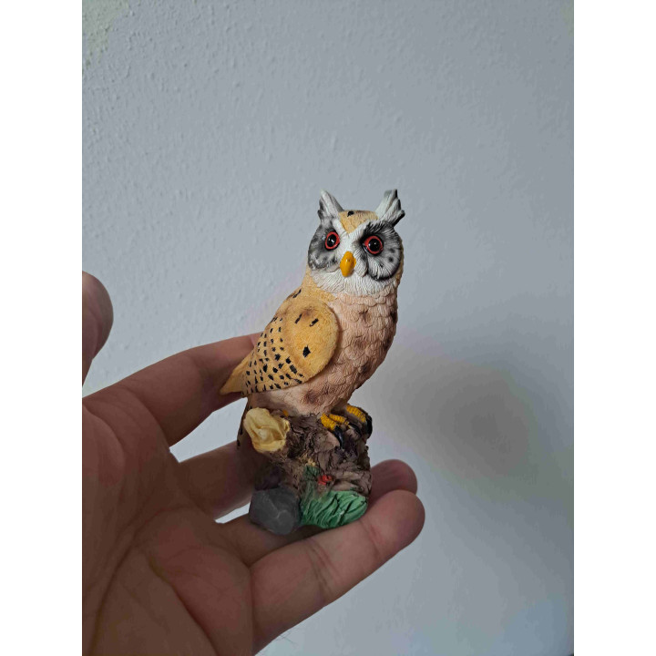 Uil met grote ogen van kunsthars staand op een boomstronk