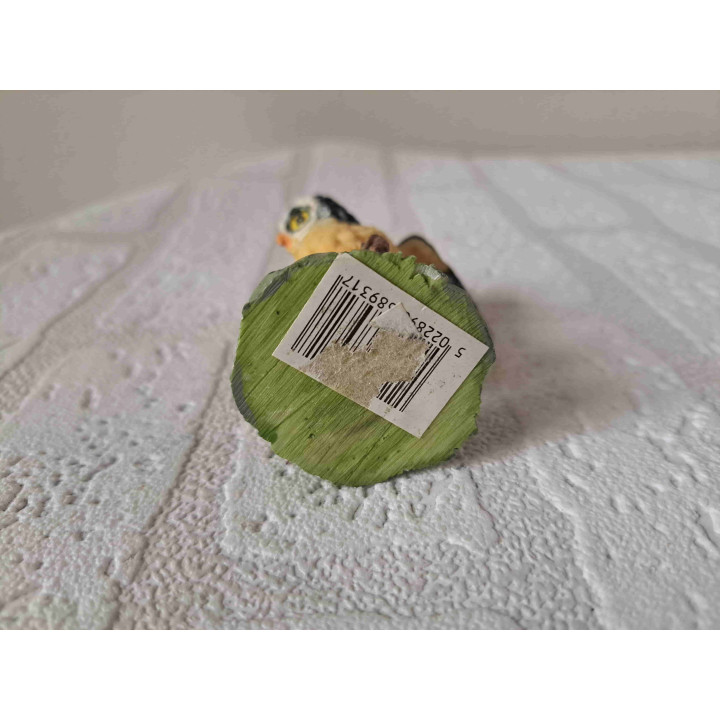 Uil met open vleugels staand op een tak van kunsthars