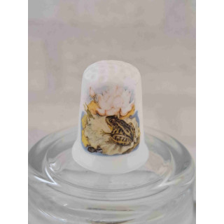 Kikker op een waterlelieblad op een porselein vingerhoedje