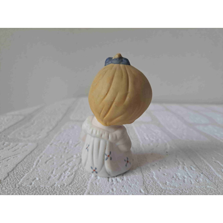 Biscuit porselein beeldje van meisje met blauwe strik in haar