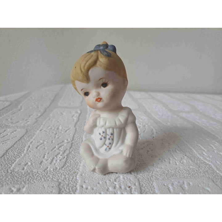 Biscuit porselein beeldje van meisje met blauwe strik in haar