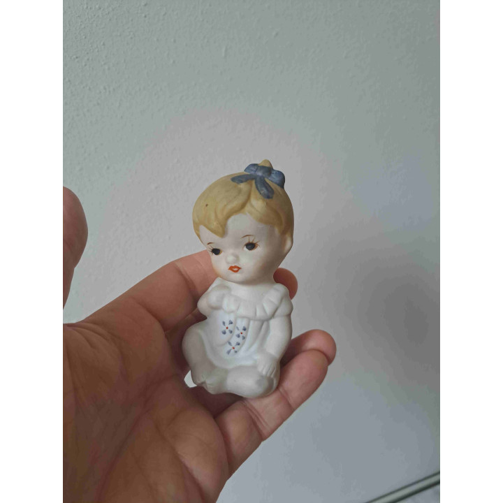 Biscuit porselein meisje met blauwe strik 5x6x8.5cm