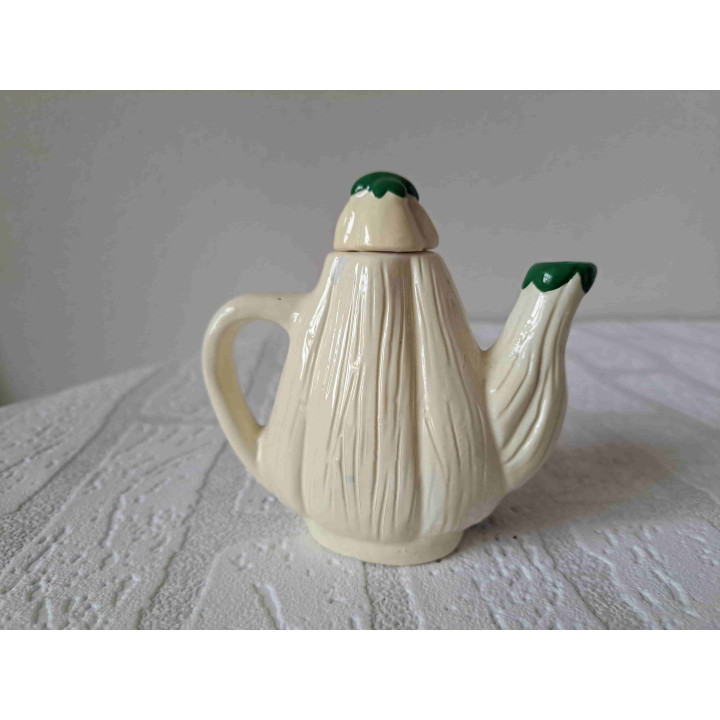 Theepotje in een vorm van een groente aubergine creme