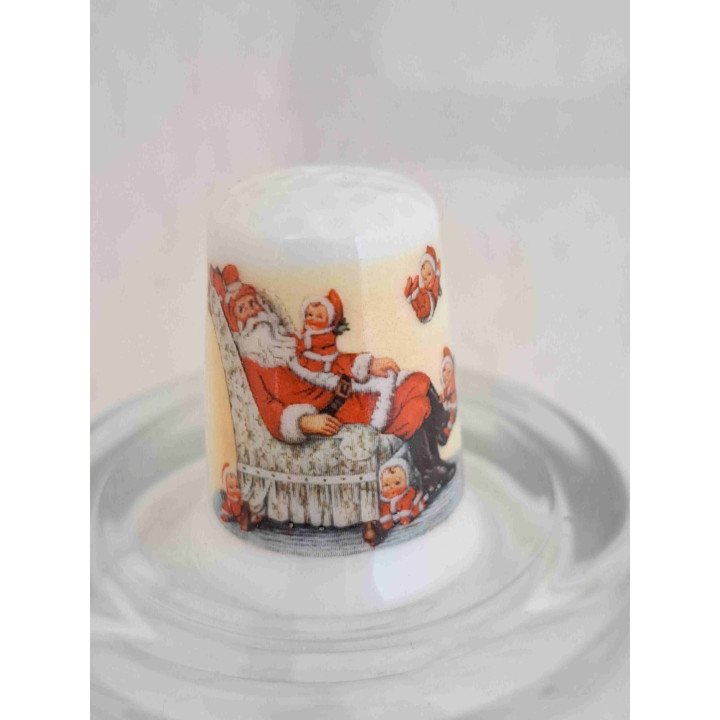 Kerstman zittend in stoel op een porselein vingerhoedje