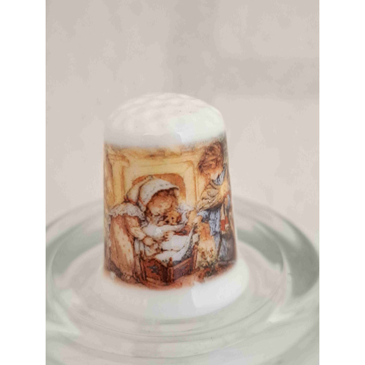 Kerststal met meisje en jong op een porselein vingerhoedje