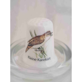 Kleine Karekiet vogel op een porselein vingerhoedje