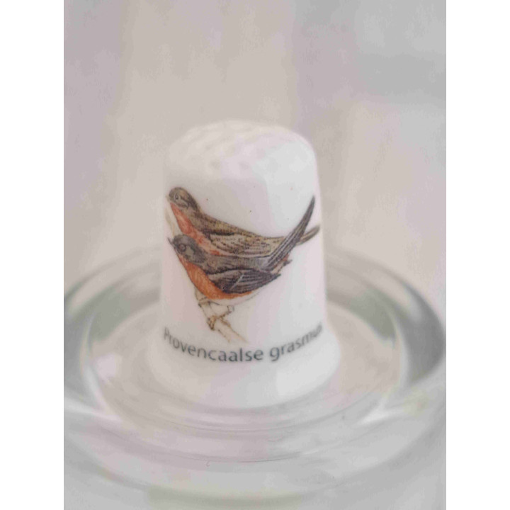 Provencaalse grasmussen vogel op een porselein vingerhoedje