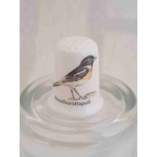 Roodborsttapuit vogel op een porselein vingerhoedje