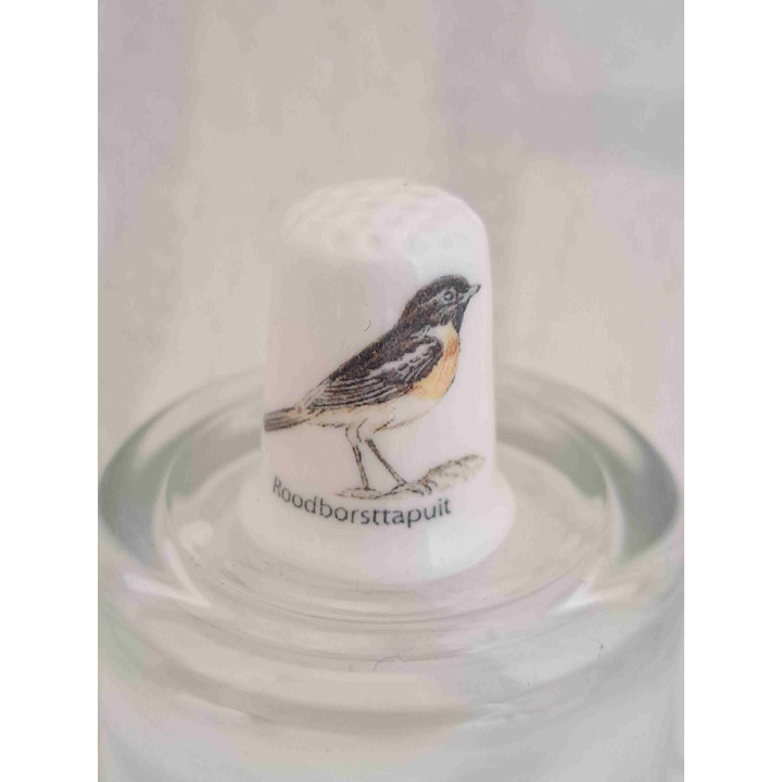 Roodborsttapuit vogel op een porselein vingerhoedje